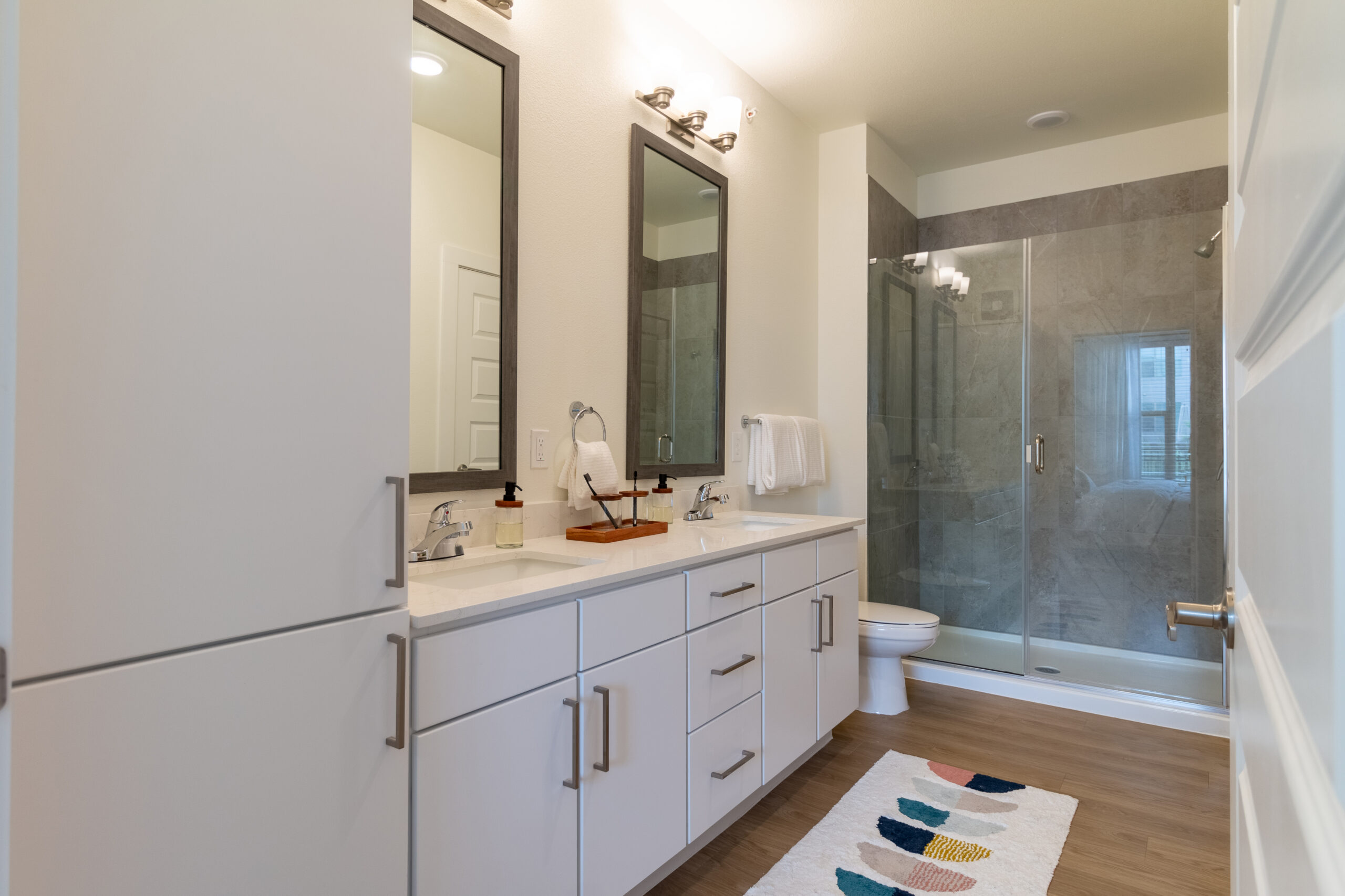 Clean and contemporary bathroom with double vanity at Potranco Commons