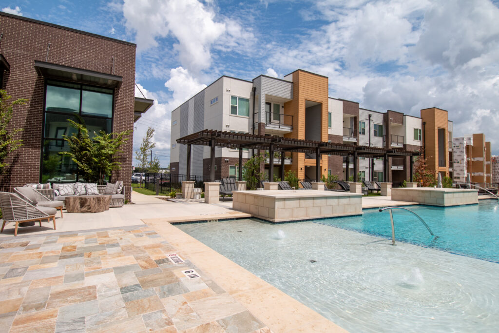 Resort-style swimming pool with lounge seating at Potranco Commons apartments in West San Antonio