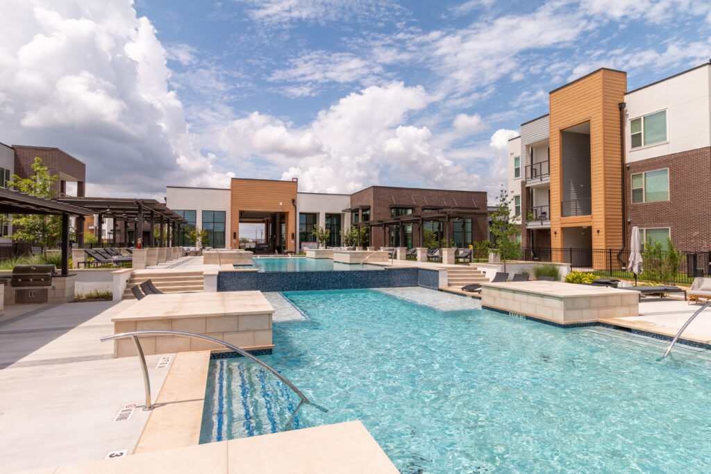 Resort-style pool with lounge chairs and a shade pergola at Potranco Commons in San Antonio